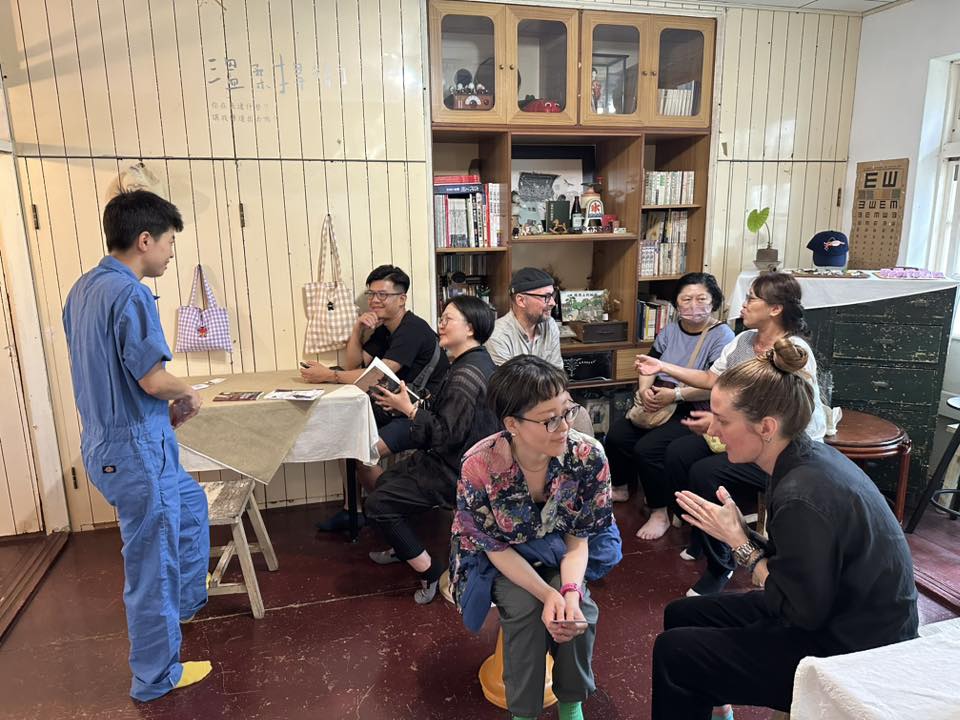 A group of people in a wood-panelled room, chatting.